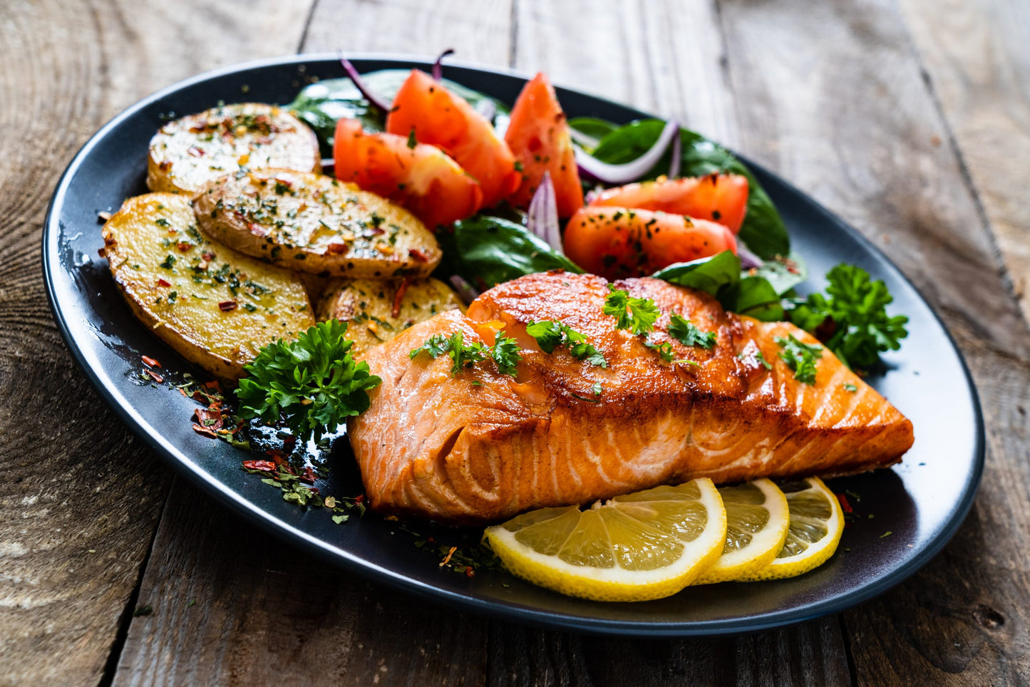 Fried,Salmon,Steak,With,Potatoes,And,Vegetables,On,Wooden,Table